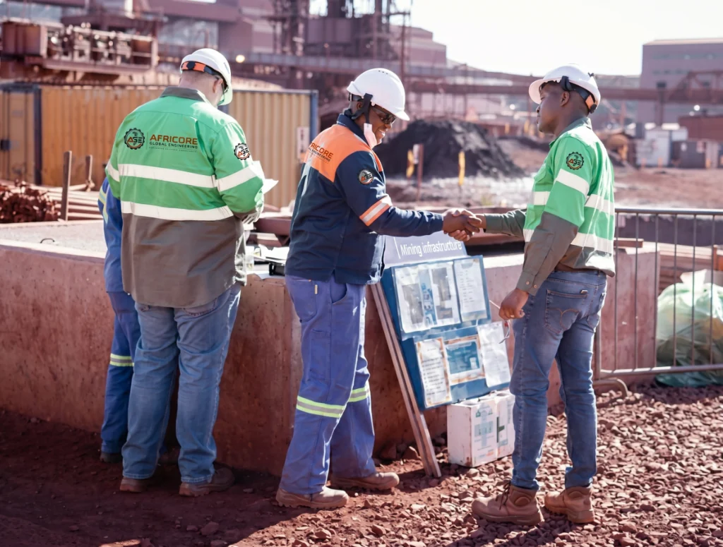 Africore engineers in branded PPE collaborating on site